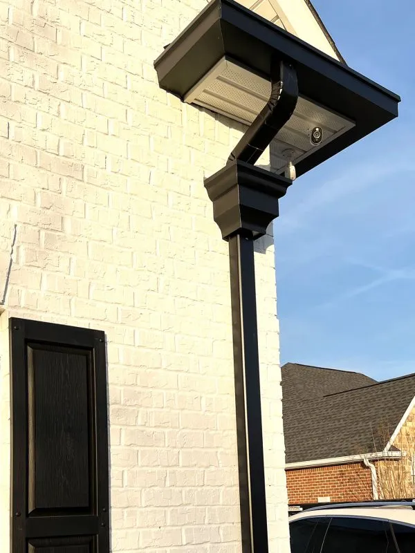 Black gutter and downspout on brick home