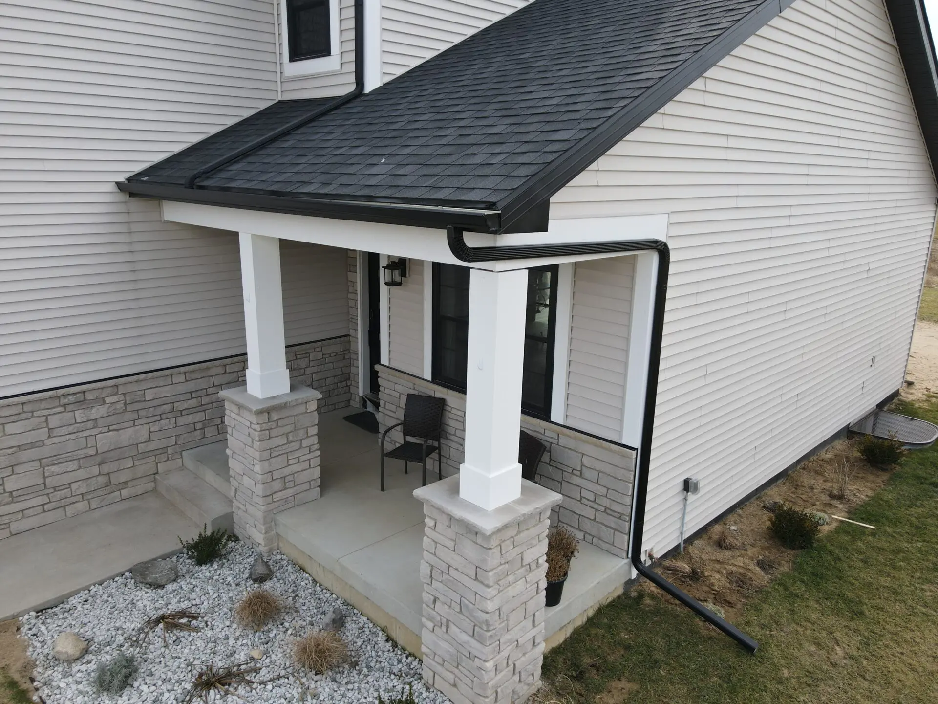 Porch with black gutters and shingle roof
